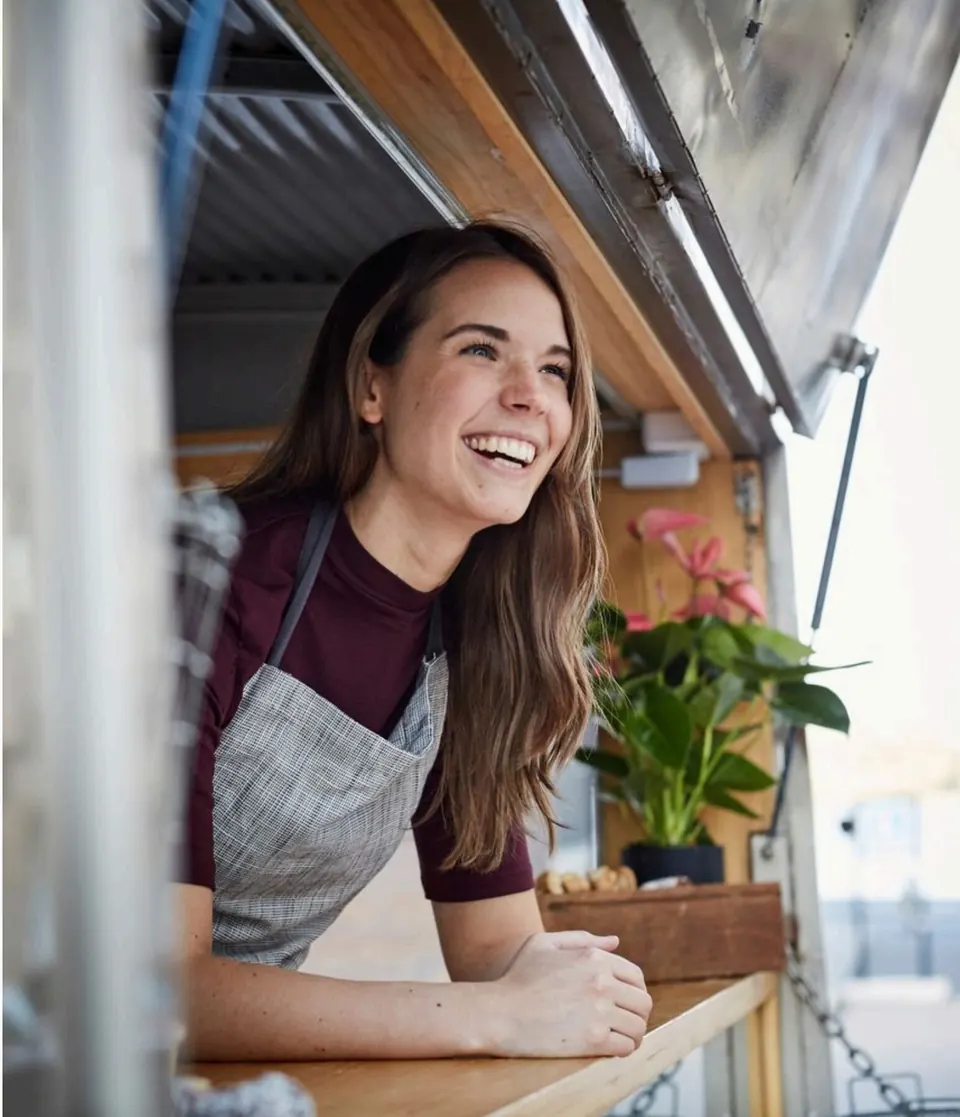 Emprendedora sonriendo desde su negocio móvil